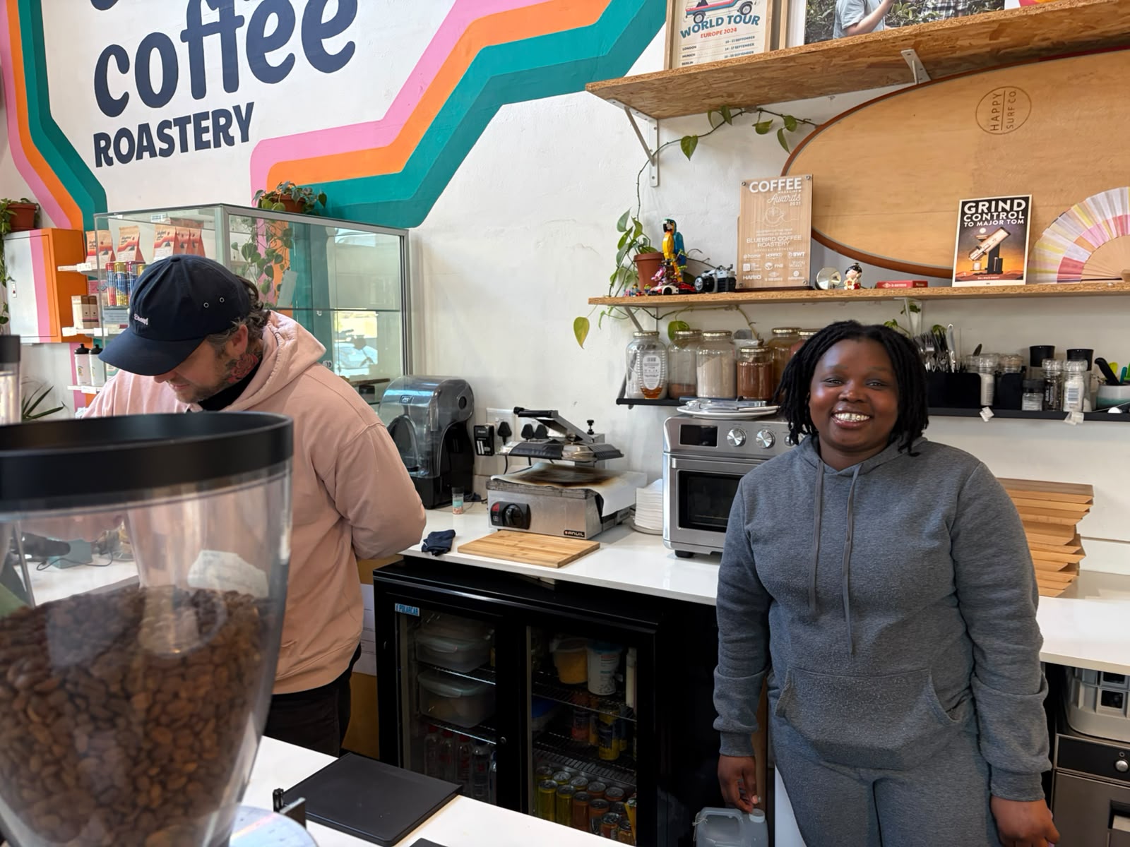 The Bluebird team behind the bar — good vibes, good coffee, and a Coffee World Tour poster on the shelf