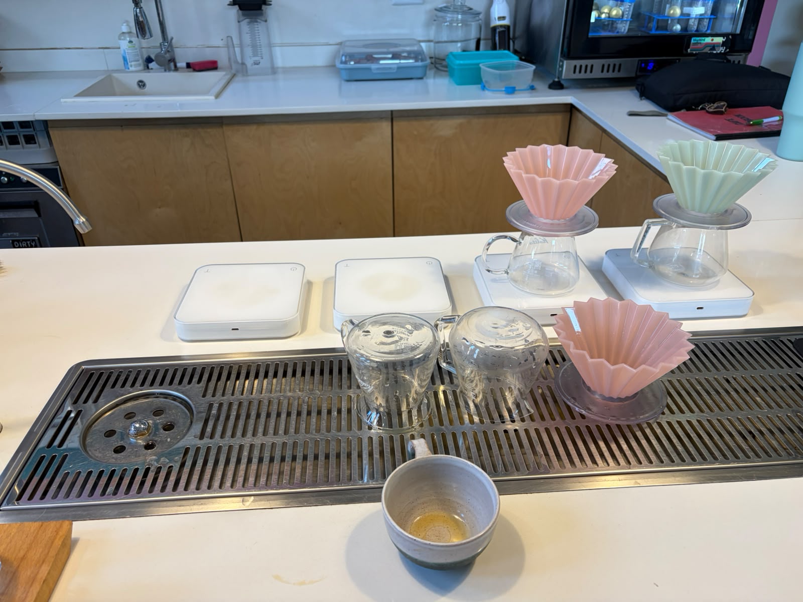 Origami drippers in pink and mint green, sitting on Acaia scales at the Bluebird brew bar