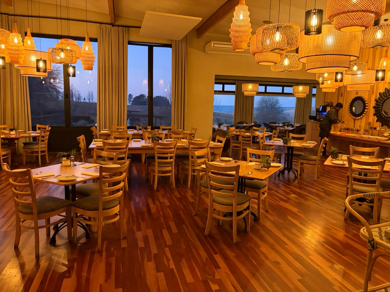 The Brahman Hills restaurant — wooden tables, woven pendant lights, and Midlands views through the windows