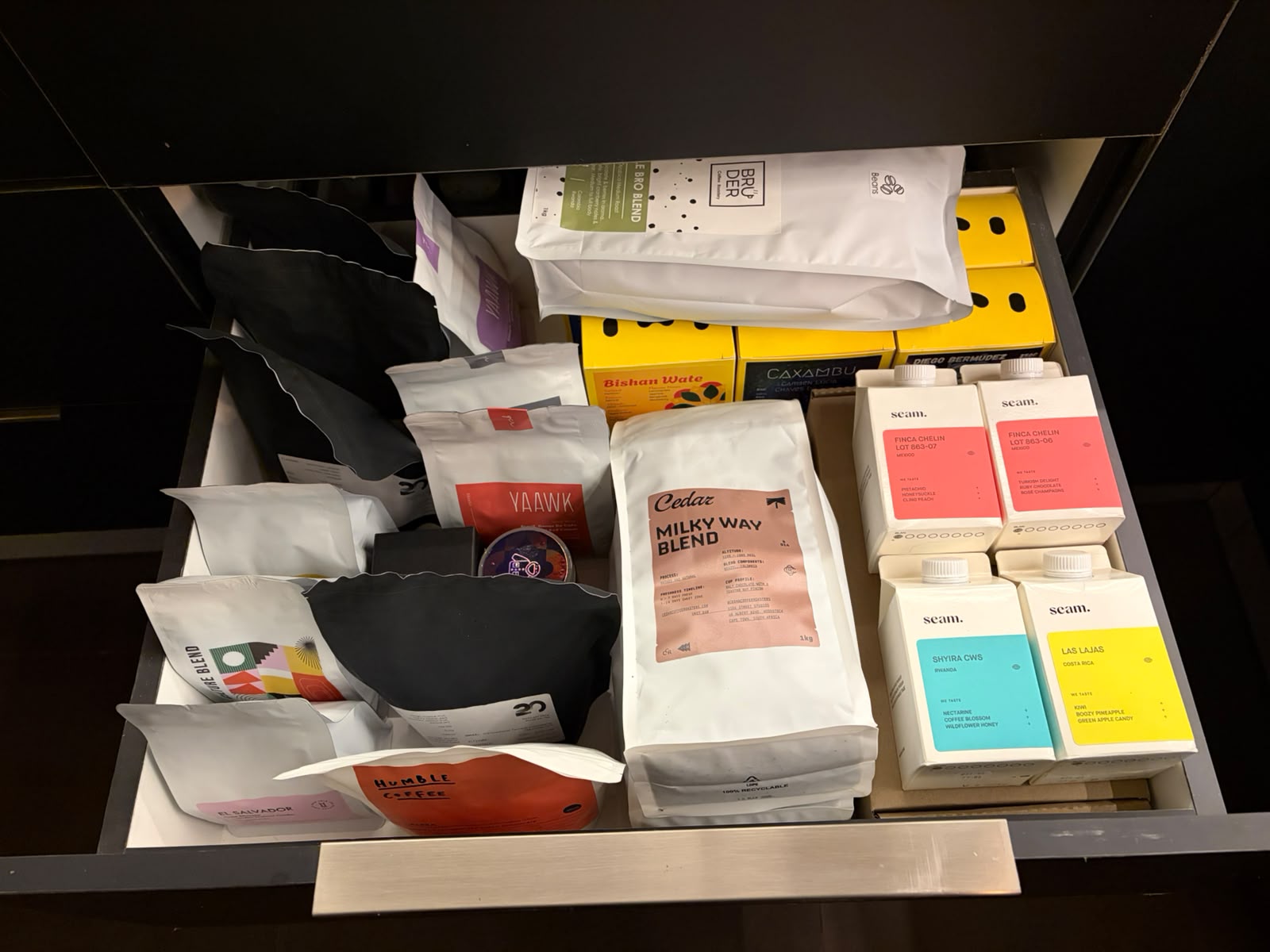 Bean drawer at Jo'burg Coffee Festival 2026 — Cedar Milky Way, Humble, YAAWK, Seam, Brüder, and Caxambu bags side by side