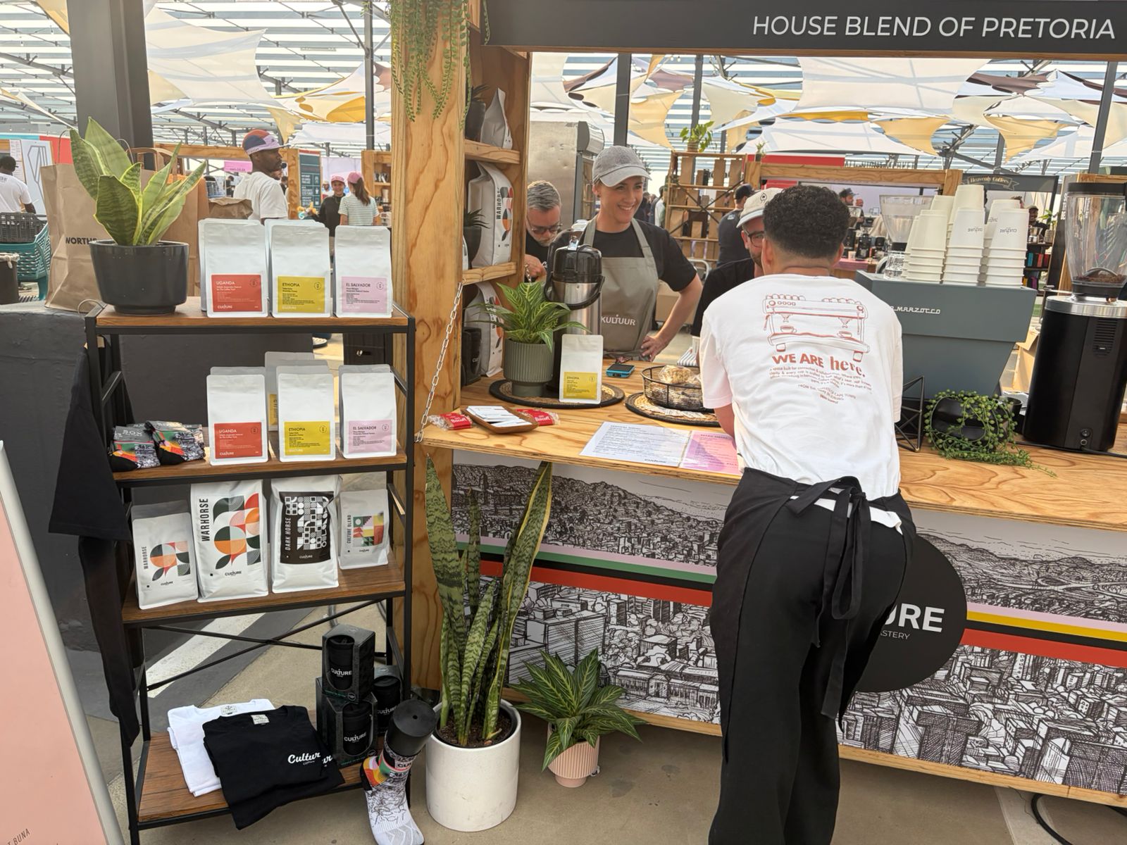 Culture Coffee stand at Jo'burg Coffee Festival 2026 — HOUSE BLEND OF PRETORIA banner, Pretoria skyline art, Warhorse bags