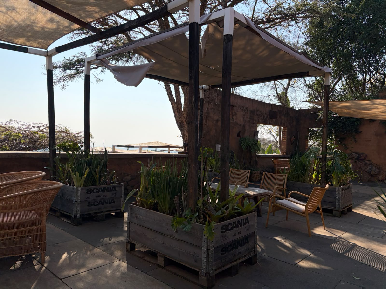 Outdoor seating with shade sails and Scania crate planters at The Ruins