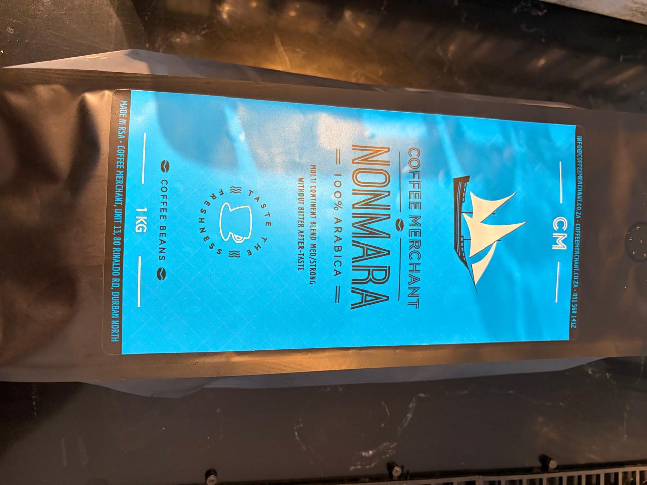 Coffee Merchant Nonmara 1 kg bag — bright blue label, CM logo, 