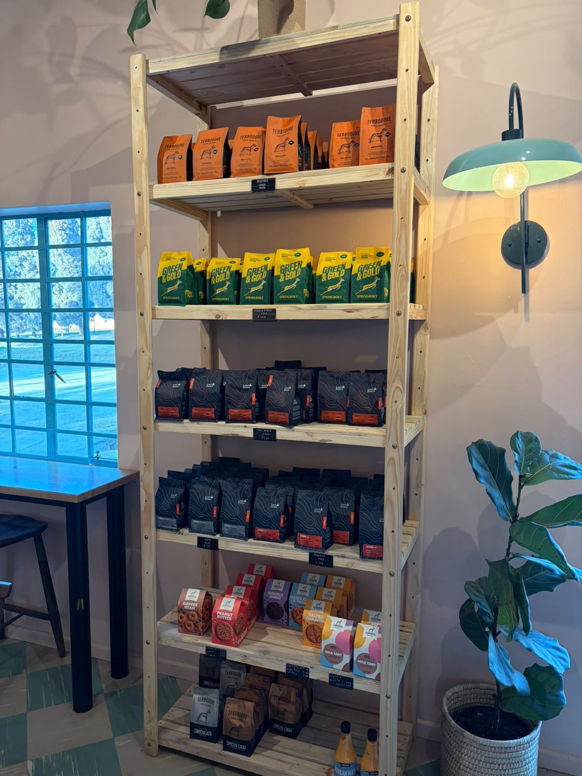 Shelf of dark Terbodore bags with orange labels, Green and Gold Springbok blend, Lazy Bones cookies