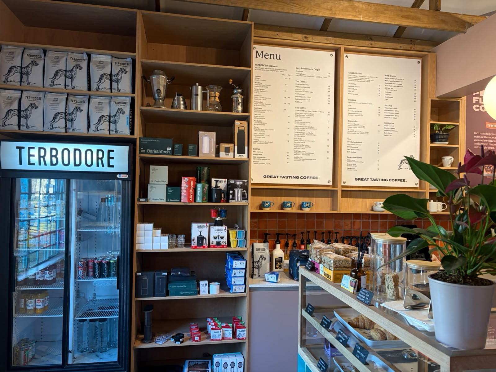 Menu boards and retail counter — Terbodore display fridge, BaristaTech equipment, brewing gear, menu panels