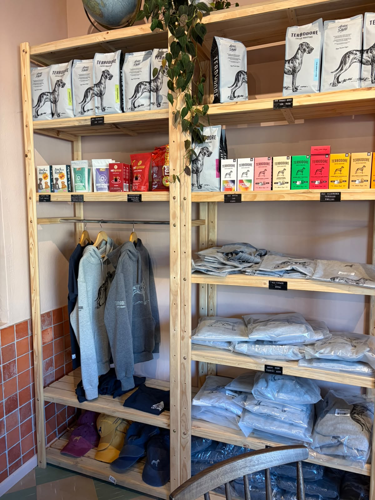 Merch corner — grey hoodies, Terbodore branded clothing, Nespresso capsule packs in coloured boxes
