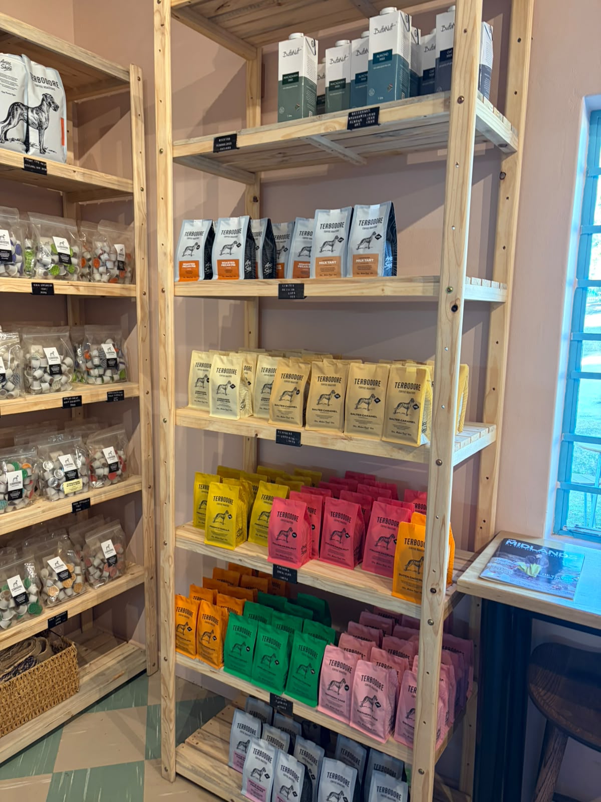 Shelf of colourful Terbodore flavoured coffee bags — yellow, pink, green, red, orange packaging