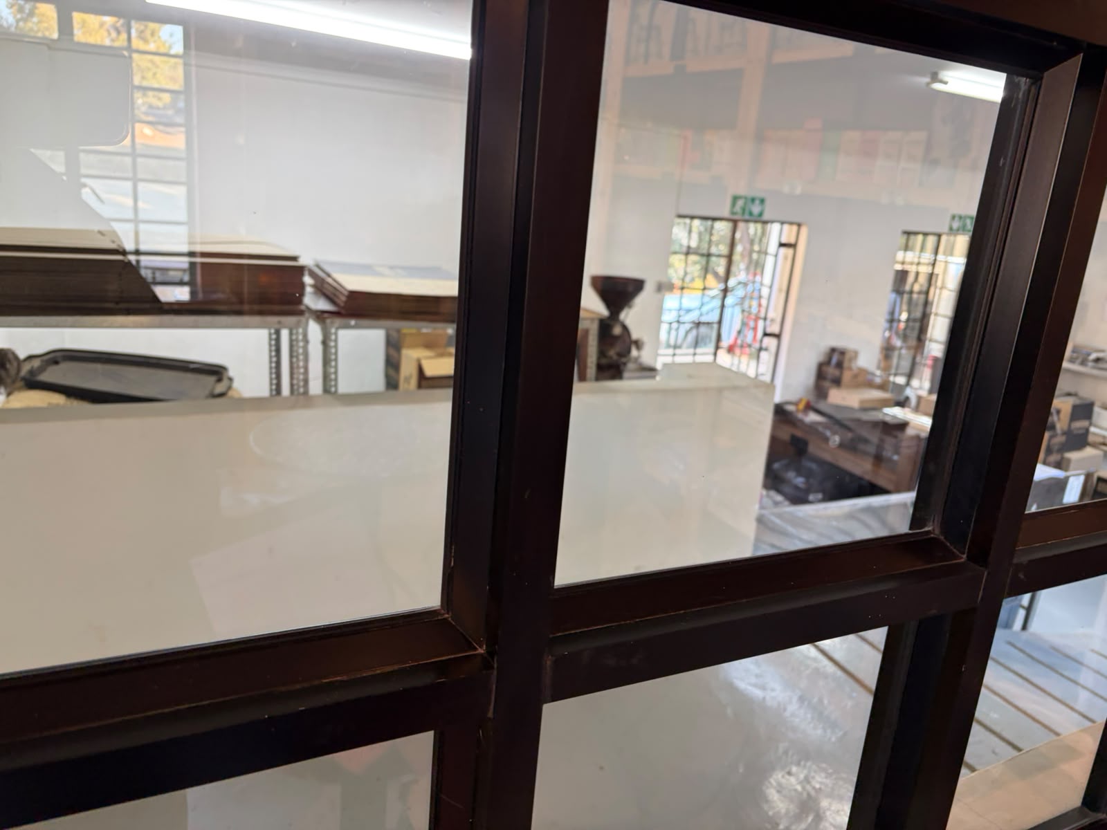 View through glass partition into the Terbodore roastery — industrial space, roasting equipment visible